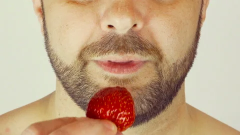 Adult man with a beard. He eats strawberries with yogurt. Vídeo Stock 107500803