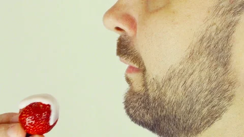 Adult man with a beard. He eats strawberries with yogurt. Stock Footage 107500856