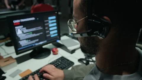 Adult Man with Headset Working at Computer in Scam Call Center Stock Footage 346703042