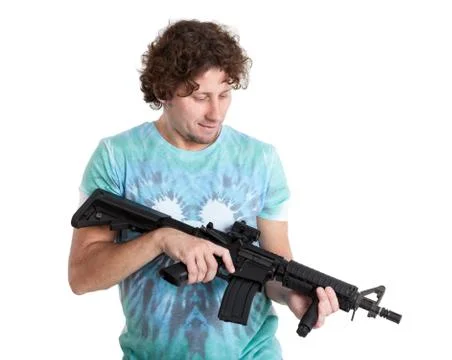 Adult man holding machine gun in hands and looking at weapon, isolated on whi Fotos de archivo