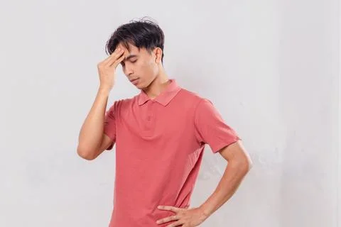 Adult man looking down while holding his head, showing stress and frustrati.. Stock Photos