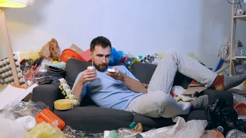 Adult man lying on the sofa, drinking beer (or soda) and watching tv. Video stock 120422975