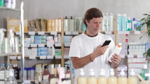 Adult man scanning qr code of sunscreen Stock-Footage 342127412