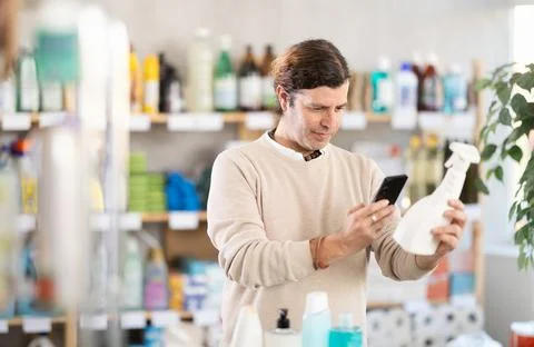 Adult man scanning qr code for cleaning spray Foto stock