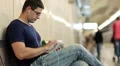 Adult man with tablet pc sits on the bench inside underground station HD Footage