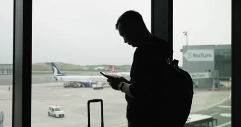 Adult man using app on smartphone, waiting for a flight, texting message working Stock Footage 293476095