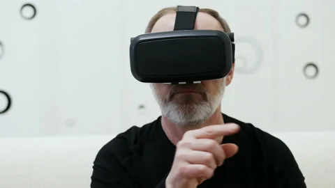 Adult man using virtual reality glasses at home with wireless headphones Stock Footage 165291284