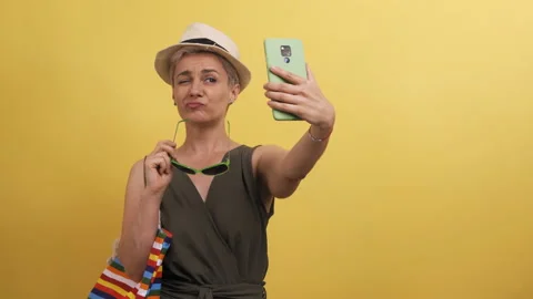 Adult model with multi-colored straw hat bag on yellow background. Blonde Stock Footage 142741470
