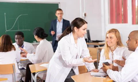 Adult people in white coats working in groups during professional training Stock Photos