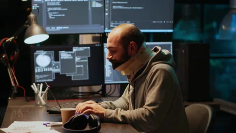 Adult programmer with neck collar foam coding html script Stock Footage 229332710