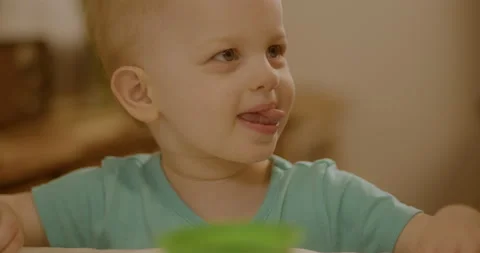 Adult pulls easter egg out of green dye and a toddler dunks it back in Stock Footage 239180006