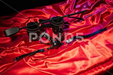 Adult sex games. Kinky lifestyle. Spank, Bondage and gag ball on the red line Stock Photos