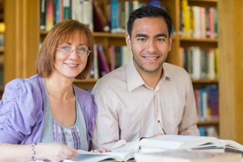 Adult students studying together in the library Stock Photos