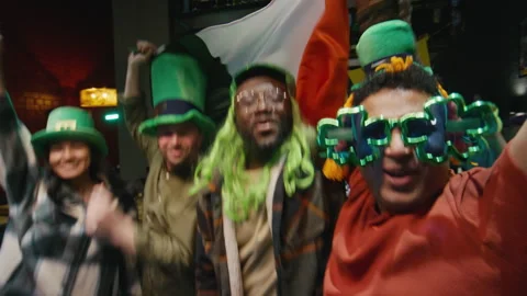 Adults in Green Hats Jumping with Flag of Ireland on Saint Patricks Day Stock Footage 261513465