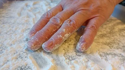 Adult's hand on a tray with flour while cooking Stock Photos