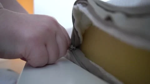 An adult's plump hand pulls the lock on the mattress cover Stock Footage 320146059