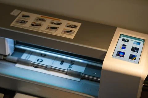 Advanced plotter cutting hydrogel film in a workshop setting for precise de.. Stock Photos