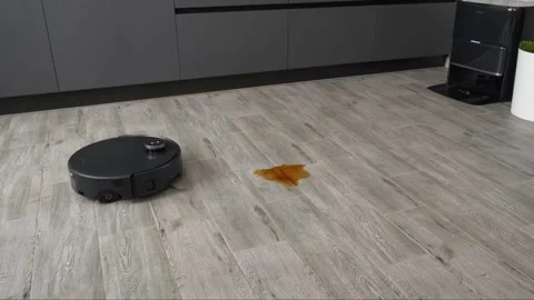 Advanced robotic cleaning appliance navigates across wooden flooring surfaces Stock Footage 345023866