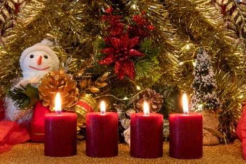 Advent theme with 4 burning red candles and Christmas lights. Stock Photos