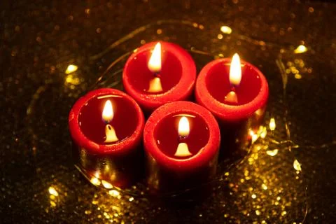 Advent theme with 4 burning red candles and Christmas lights. Stock Photos