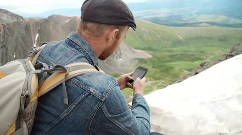 Adventure man with gps device or phone outdoors in wilderness exploring Stock Footage 65311717