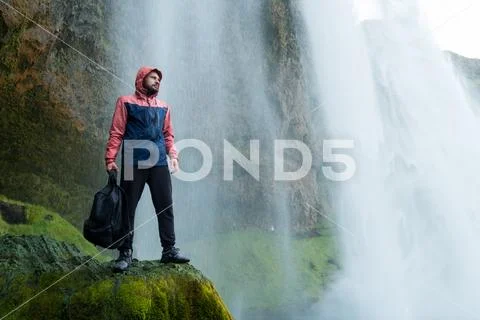 Adventure man by skogafoss waterfall, nature on Iceland. Young man visiting Stock Photos
