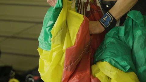 Adventure seeing sky diver adjusting parachute before jump,close up shot Stock Footage 247249151