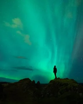 An adventure solo traveler posing with the beautiful northern lights also known Stock Photos