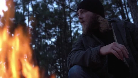 Adventurer bearded man looking around in front of a campfire. Stock Footage 76477435