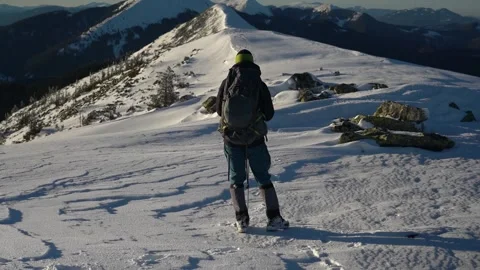 Adventurer Exploring Snow-Covered Mountain Trail in Winter Forest at Sunset. Stock Footage 280356858