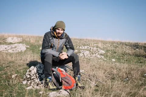 Adventurer man resting while sitting on rock Foto stock