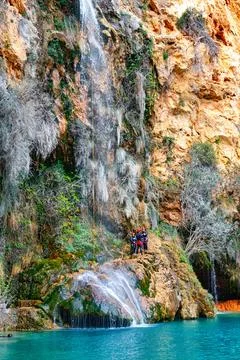 Adventurers Exploring a Vibrant Waterfall in a Picturesque Canyon During Daytime Stock Photos