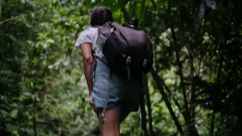 Adventurous backpacker as she embarks on a journey through lush jungles Stock Footage 252035903