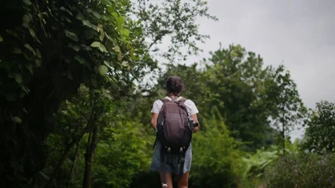 Adventurous backpacker as she embarks on a journey through lush jungles Stock Footage 252035906