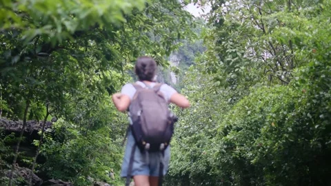 Adventurous backpacker as she embarks on a journey through lush jungles Stock Footage 252035920