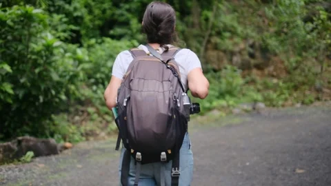 Adventurous backpacker as she embarks on a journey through lush jungles Stock Footage 252035990