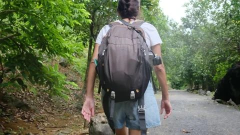 Adventurous backpacker as she embarks on a journey through lush jungles Stock Footage 252036033
