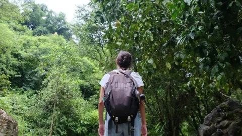 Adventurous backpacker as she embarks on a journey through lush jungles Stock Footage 252036078