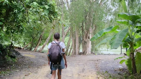 Adventurous backpacker as she embarks on a journey through lush jungles Stock Footage 252036096