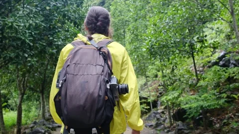 Adventurous backpacker as she embarks on a journey through lush jungles Stock Footage 252036136