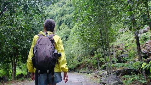 Adventurous backpacker as she embarks on a journey through lush jungles Stock Footage 252036143