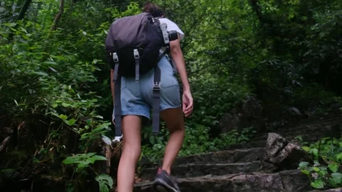 Adventurous backpacker as she embarks on a journey through lush jungles Stock Footage 252036647