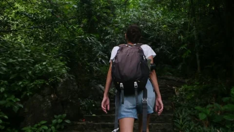 Adventurous backpacker as she embarks on a journey through lush jungles Vídeos de archivo 252036651