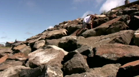 Adventurous boy climbing rocks Video stock 536440
