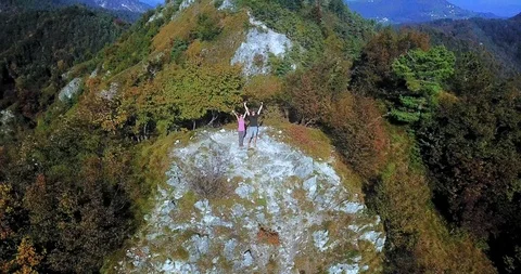Adventurous couple cheering at the top of a mountain Stock Footage 112385779