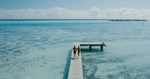Adventurous couple jumping into the ocean Stock Footage 115373131