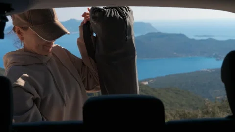 Adventurous female hiker getting backpack from car trunk Stock-Footage 330136713