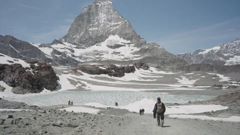 Adventurous hiker exploring the stunning alpine scenery of the snowy swiss alps 스톡 동영상 339045234