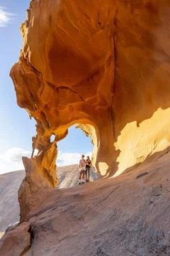 Adventurous Hikers Exploring Arco De Las Penitas in Golden Afternoon Light Foto stock