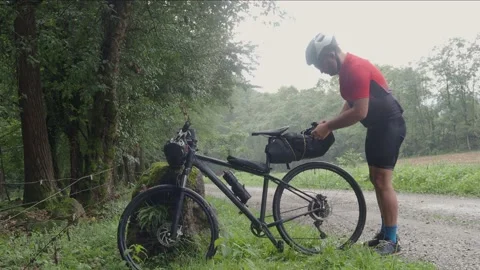 Adventurous man with a bicycle applying a backpack. Bikepacking, Stock Footage 164866265